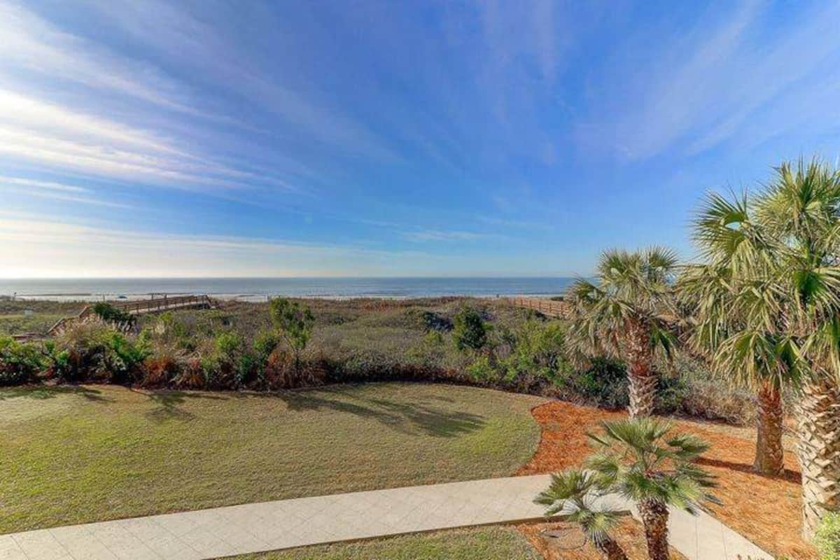 Panoramic ocean view from balcony — Atlantic Ocean, boardwalk, dunes, palm trees, and blue sky