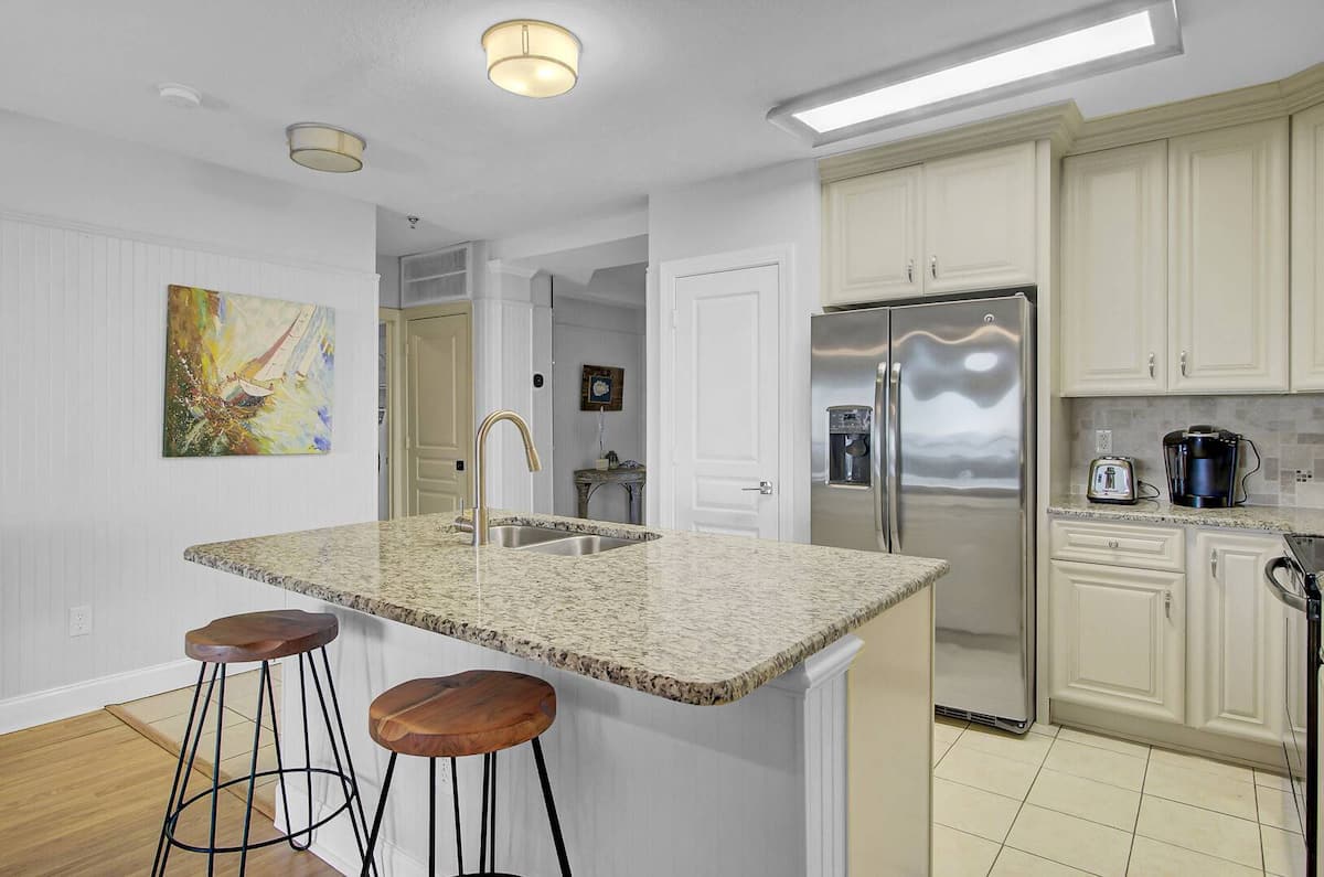Kitchen showing bar stools, French-door fridge, sailboat art, and Keurig coffee station