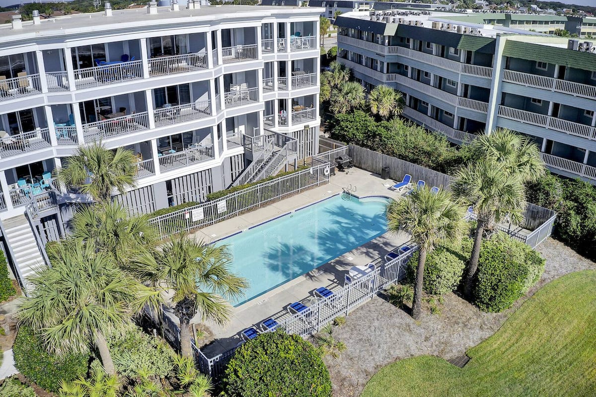Aerial drone view of pool courtyard between 1140 Ocean Blvd and neighboring buildings
