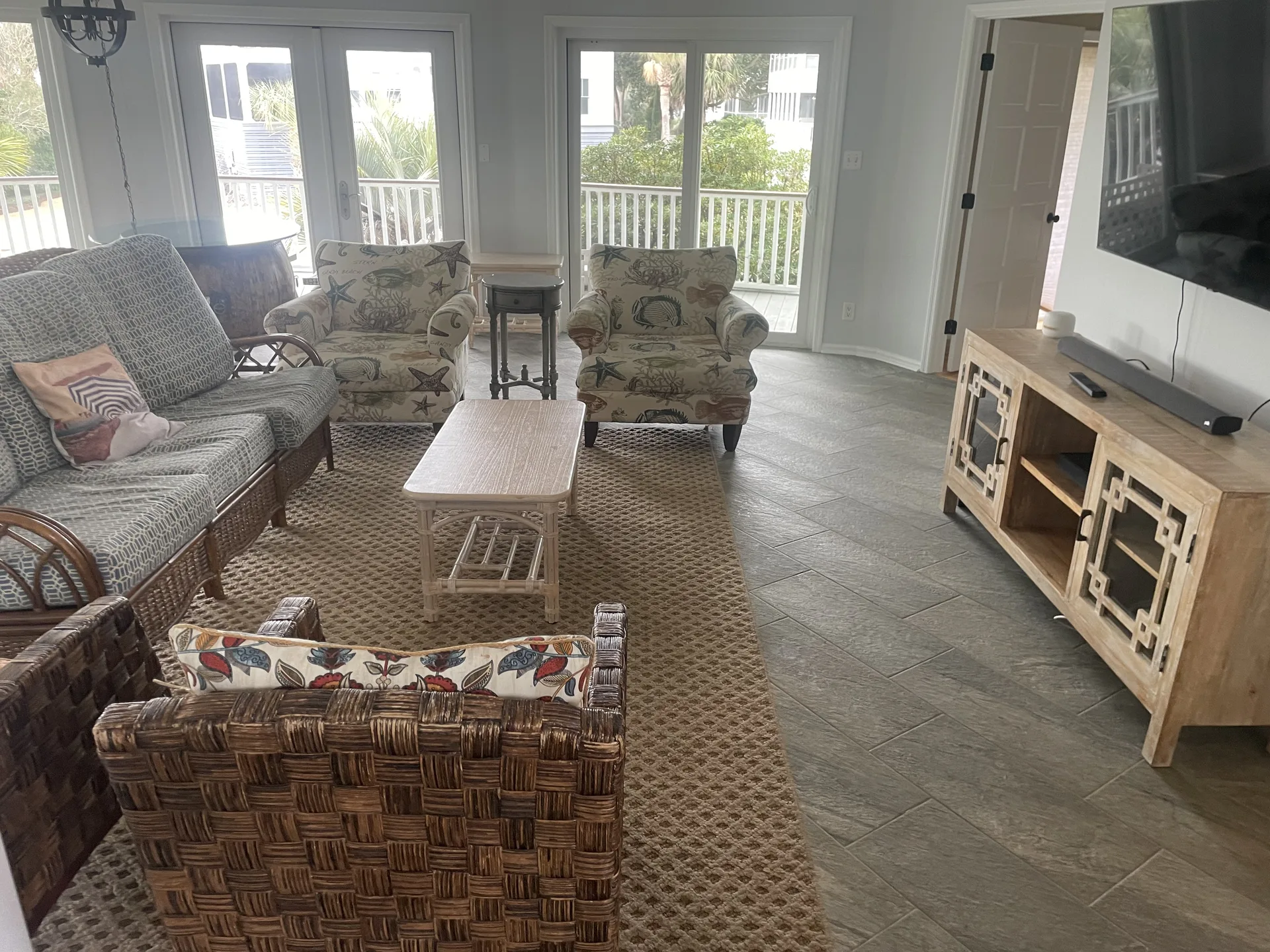 Spacious living room with coastal decor, wicker furniture, and natural light at 4 46th Avenue Isle of Palms